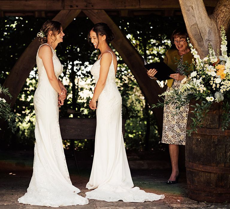 Brides laugh together as they participate in their wedding ceremony 