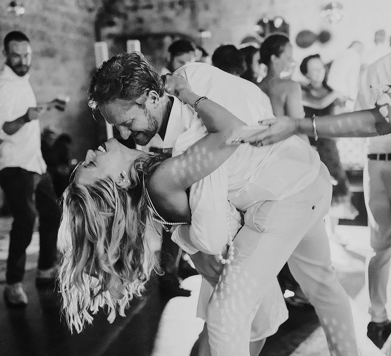 Groom leans the bride back as they dance for their wedding reception 