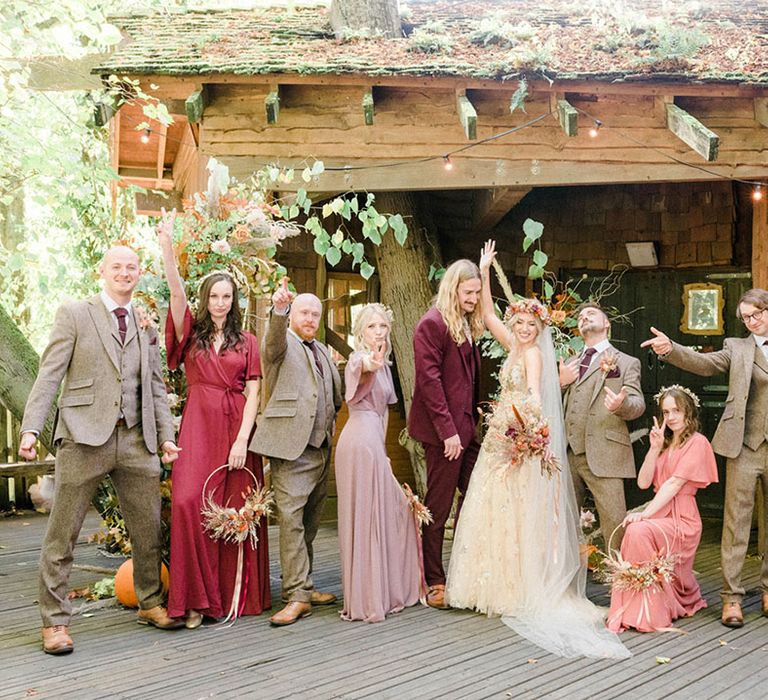 Bride & groom stand with their groomsmen in tartan suits and bridesmaids in Rewritten Bridesmaid dresses 