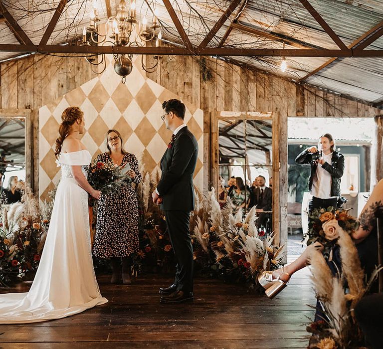 Bride & groom marry surrounded by dried floral arrangements at The Dreys wedding venue 