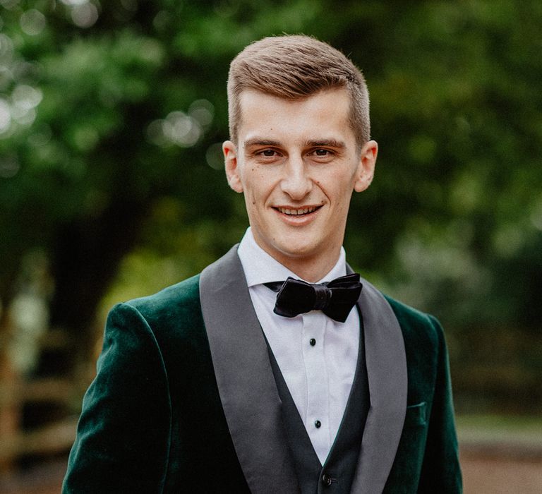 The groom wears a crushed velvet green tuxedo with no buttonhole for the rustic luxe Silchester Farm wedding in Hampshire 