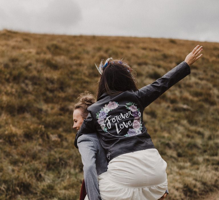 Purple rose print personalised bridal leather jacket riding piggyback with the groom 