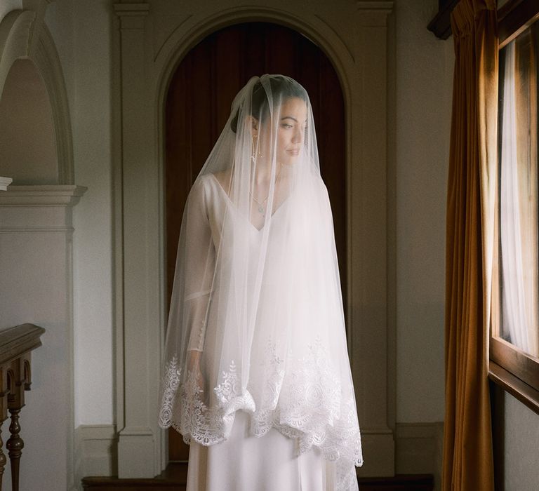 The bride in a delicate lace edge detail wedding veil by Andrea Hawke