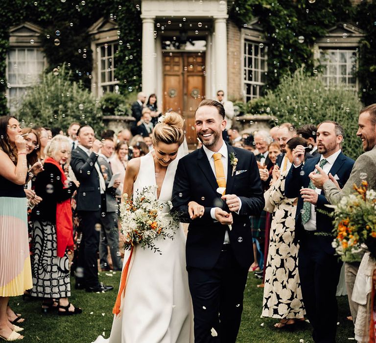 The bride and groom exit their wedding ceremony to bubbles instead of confetti 