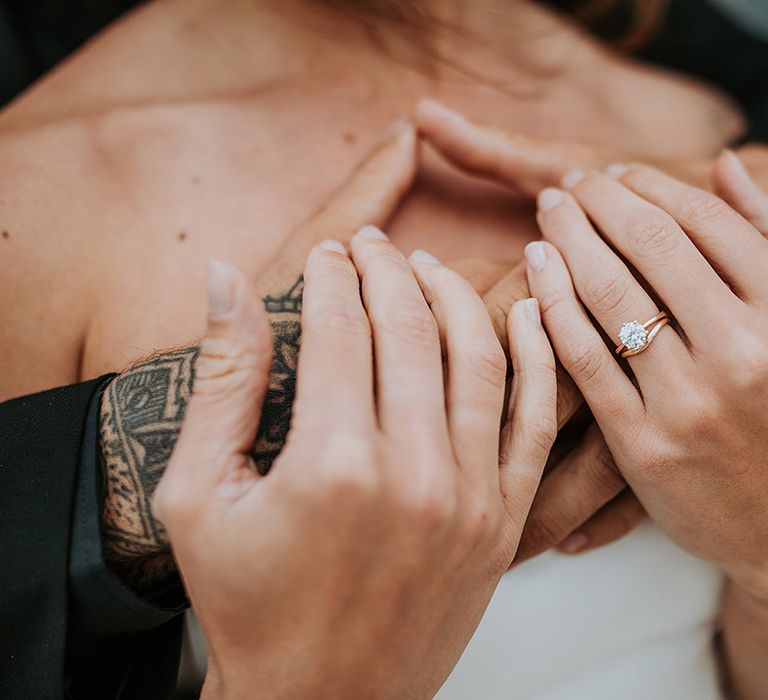 Bride wearing a round brilliant diamond engagement ring with gold band with wish bone shaped wedding band 