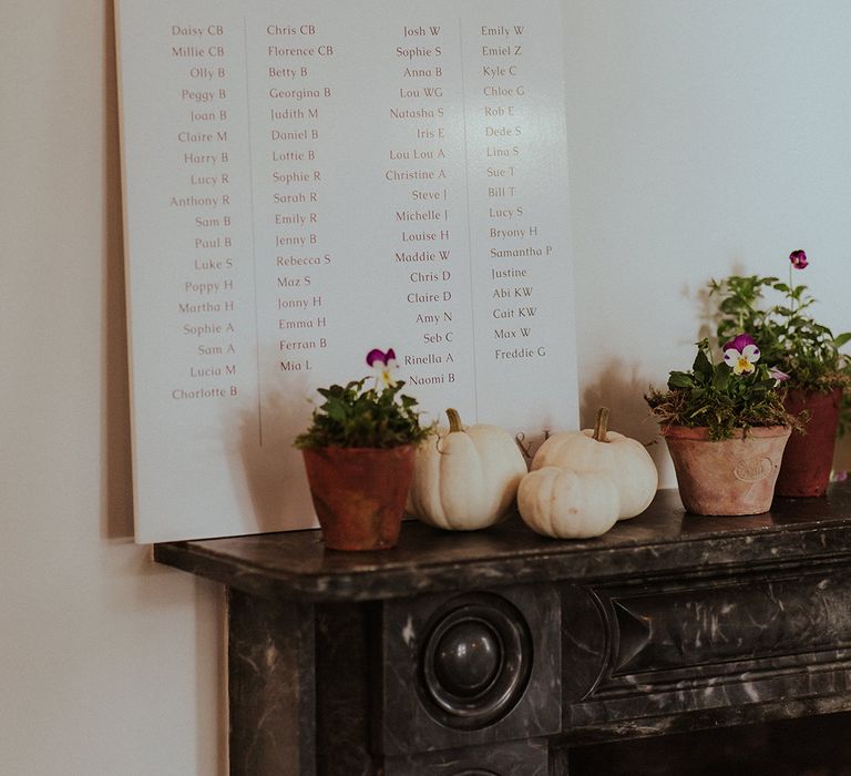 Black and white simple and minimalist wedding seating chart with white pumpkin decor 