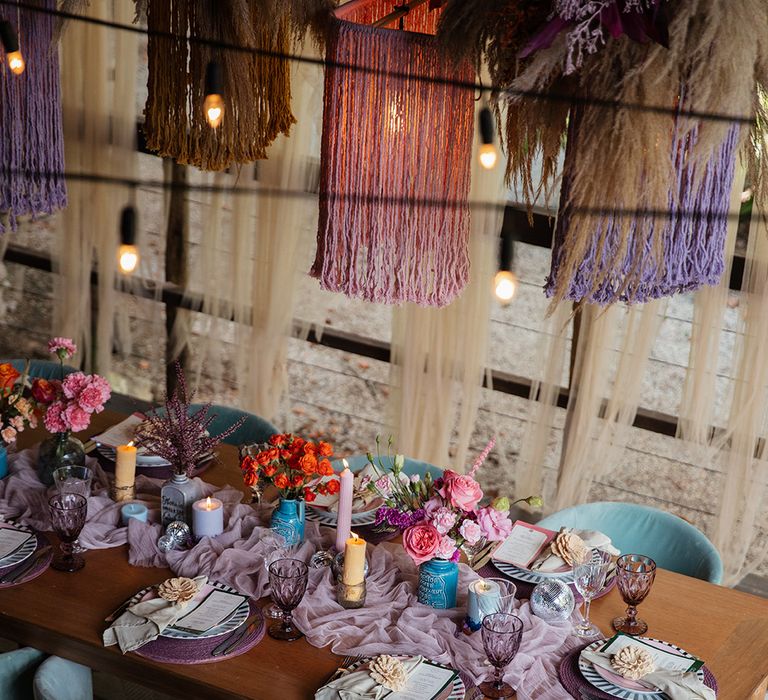 Purple lilac table runner with purple wicker place mats, tassel lighting at Villa Mandacarú Brazil wedding 