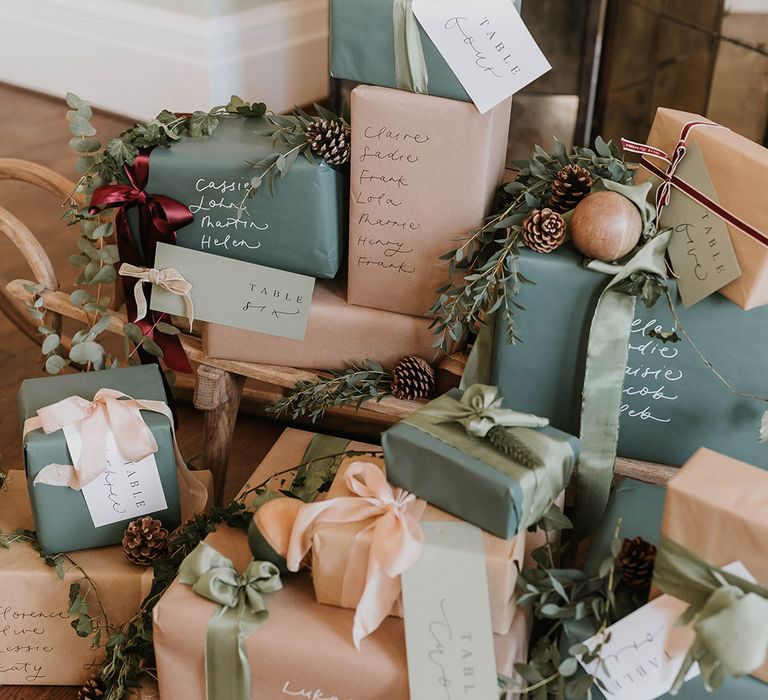 A bundle of Christmas presents at wedding wrapped in green and brown wrapping paper and white ribbons 