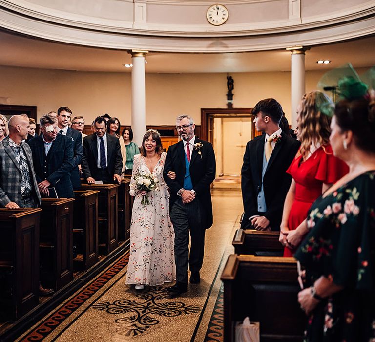 Father of the bride walking the bride down the aisle at church wedding 