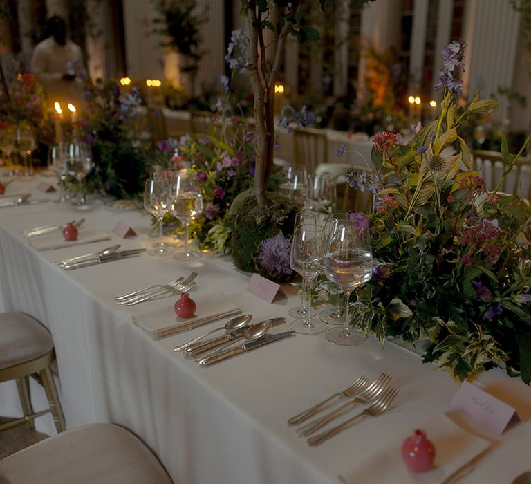 Whimsical purple wedding flowers decorating the table setting at enchanted library wedding 