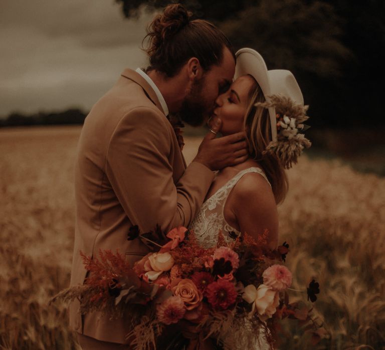 boho bride and groom with orange wedding flower bouquet 