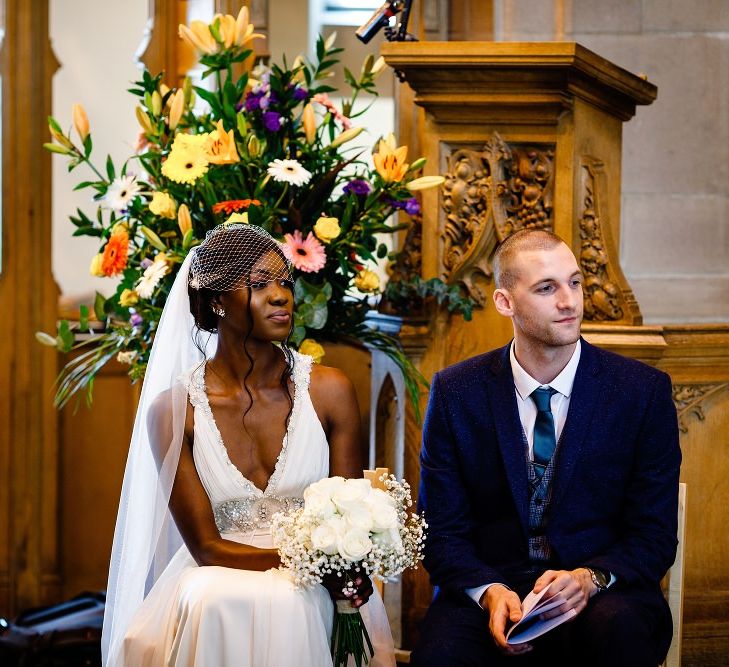 Bride and groom in the church listening to the wedding readings 