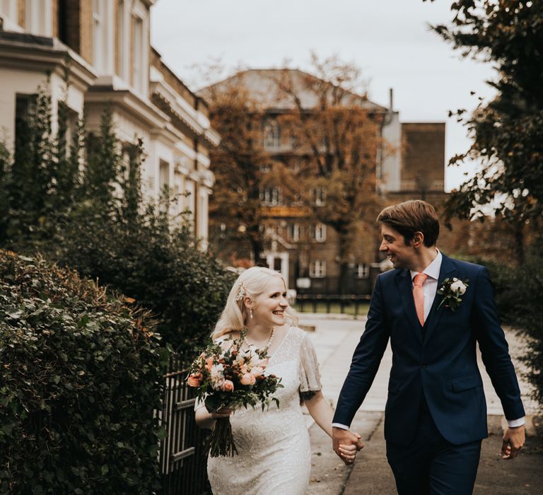 Bride & groom walk together holding hands