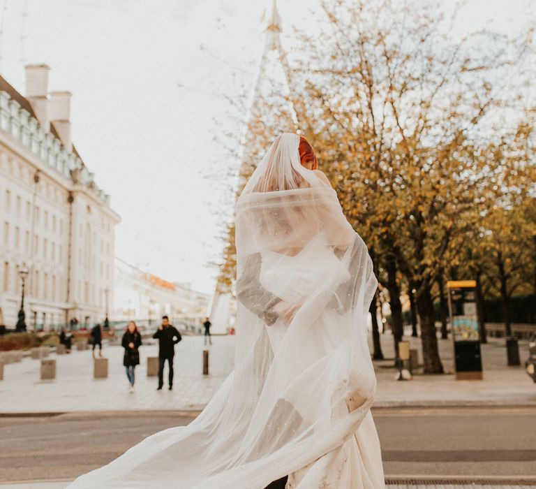 Groom holding his new bride with a view of London for intimate city elopement 