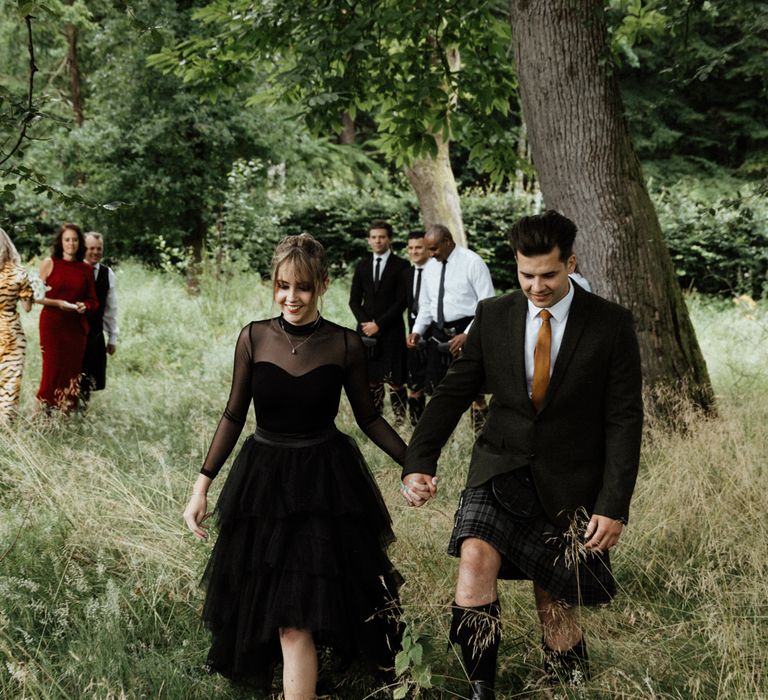 Groom wears kilt with bride wearing black wedding dress