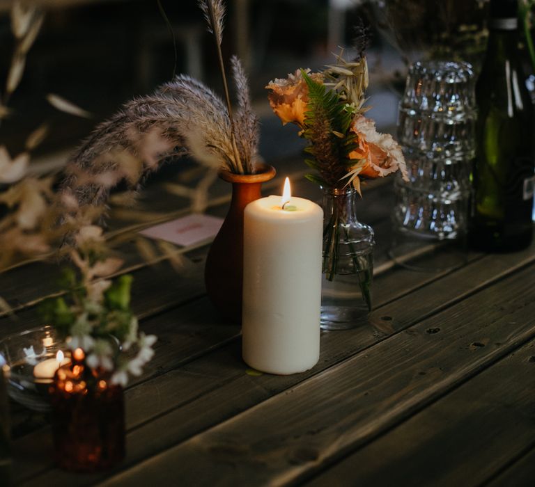 Pillar candles and bud vases on a trestle table