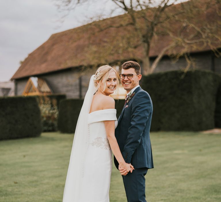 Bride & groom laugh outdoors during post-wedding photoshoot