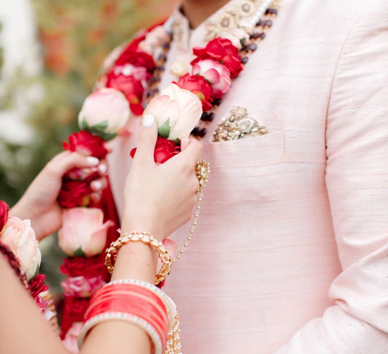 Bride places floral garland on groom