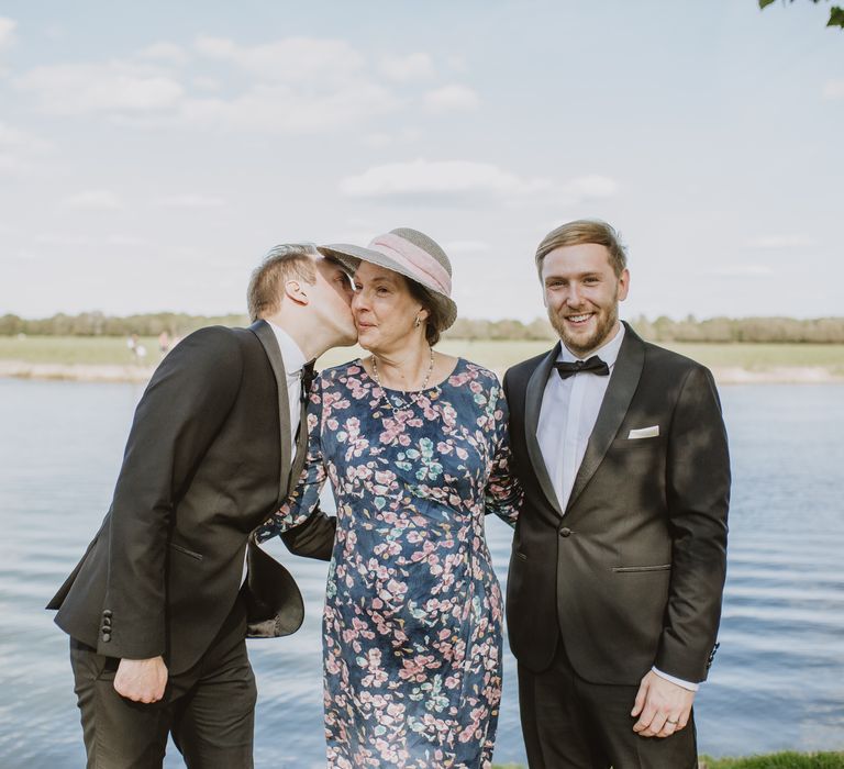 Grooms stand with wedding party with river in the background