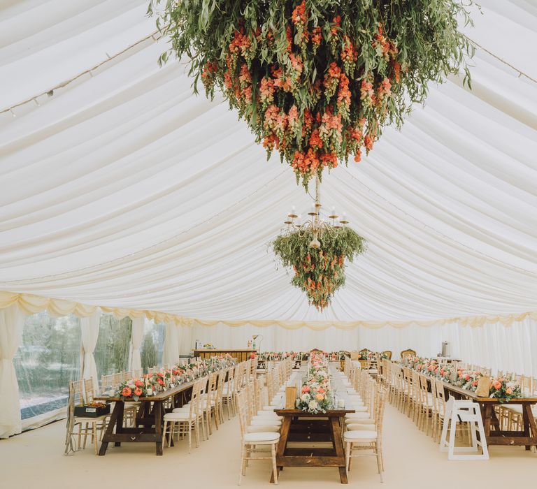 Marquee ready for wedding day complete with large hanging foliage in bright orange colouring