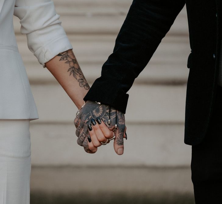 Close up of bride and groom holding hands