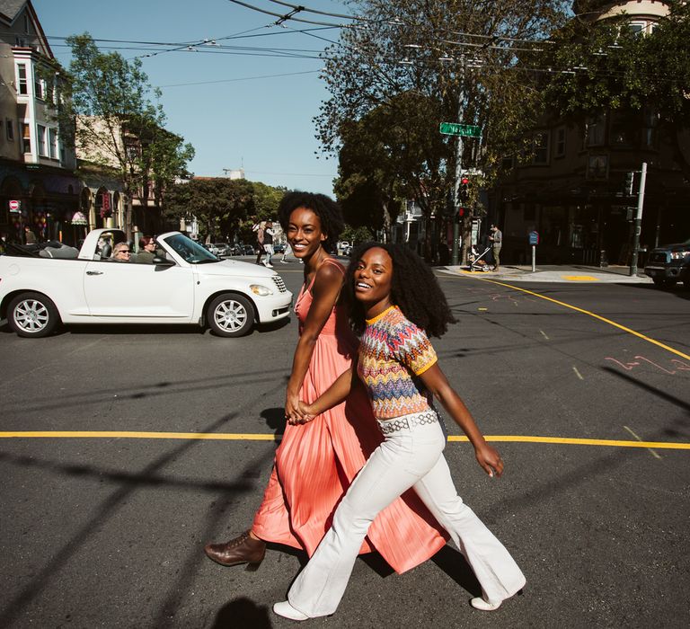 LGBTQ+ Brides-to-be crossing the road during their San Francisco engagement photoshoot 