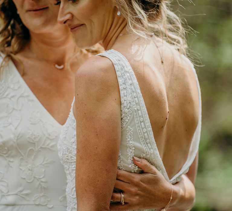 Bride places hand around wife on their wedding day