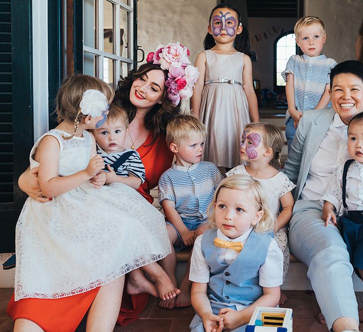 Brides pose for photos on their wedding day with children 