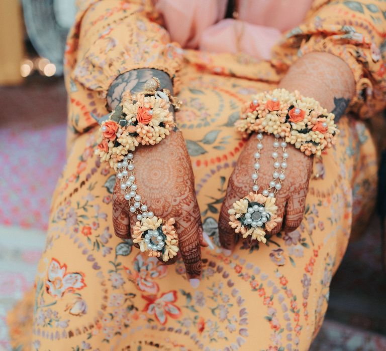 Bride wears golden outfit with pearl jewellery in the shape of flowers