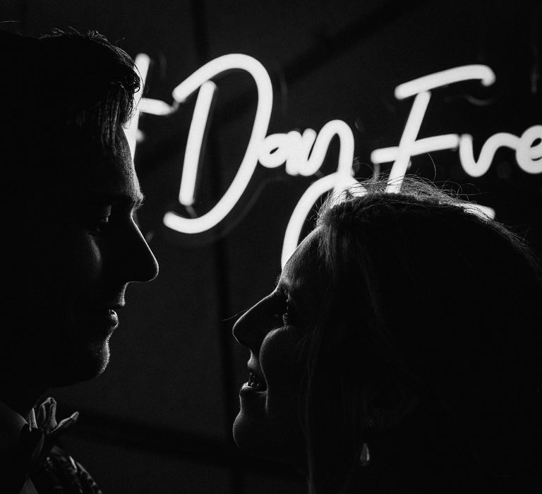 Couple kiss in front of LED lights on their wedding day