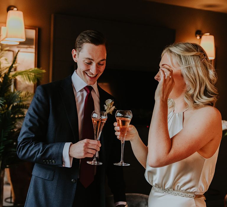 Bride and groom sipping champagne on the wedding morning 