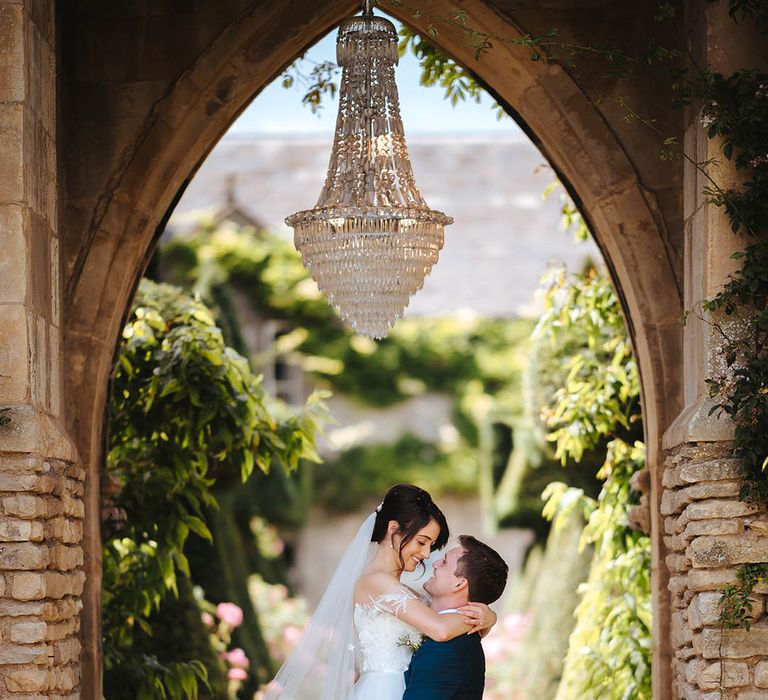 Groom lifts his bride up as they gaze lovingly into one another's eyes