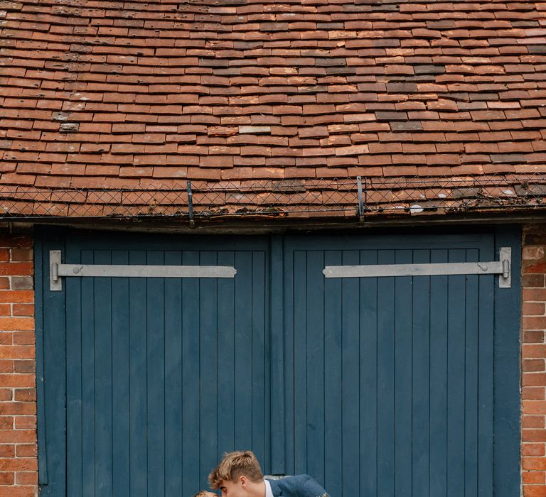 Groom leans back bride as he kisses her on their wedding day