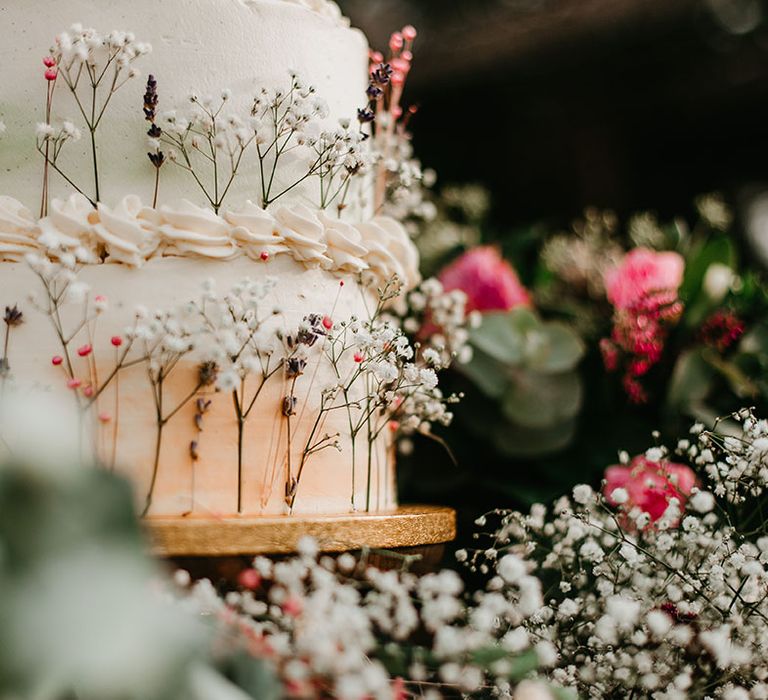 White frosted wedding cake complete with floral decor