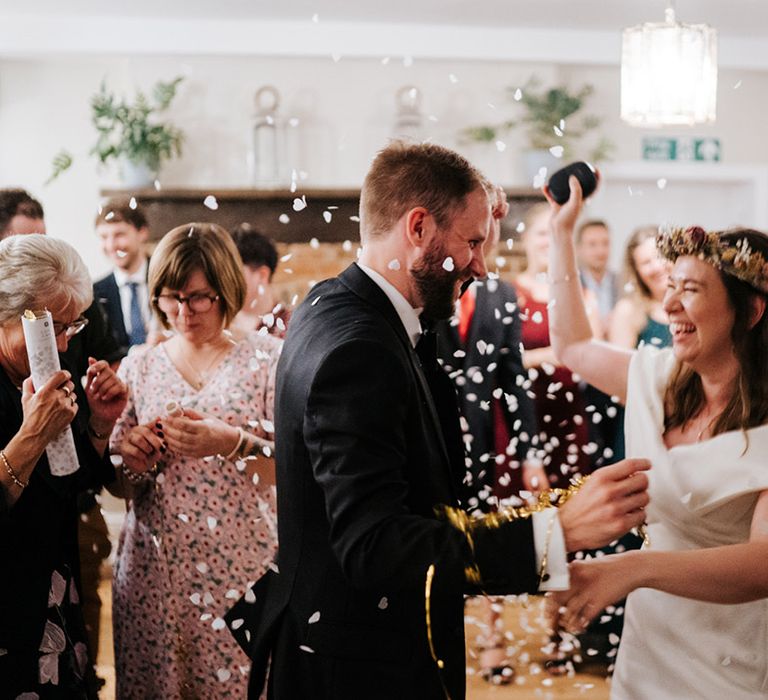 Bride & groom have confetti thrown around them on their wedding day