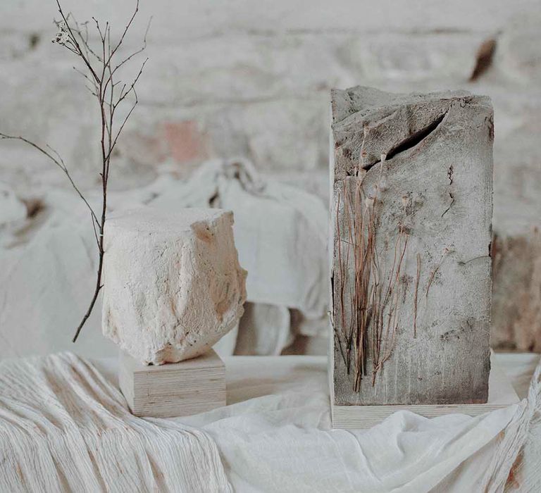 Grey and white concrete wedding cakes with dried flower stems 