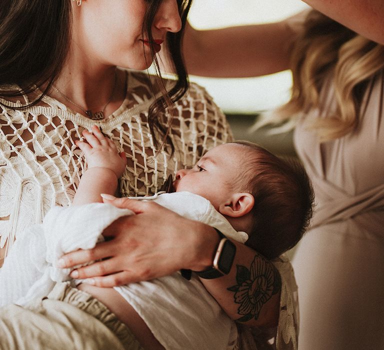 Bride cradles her baby on the morning of her wedding day