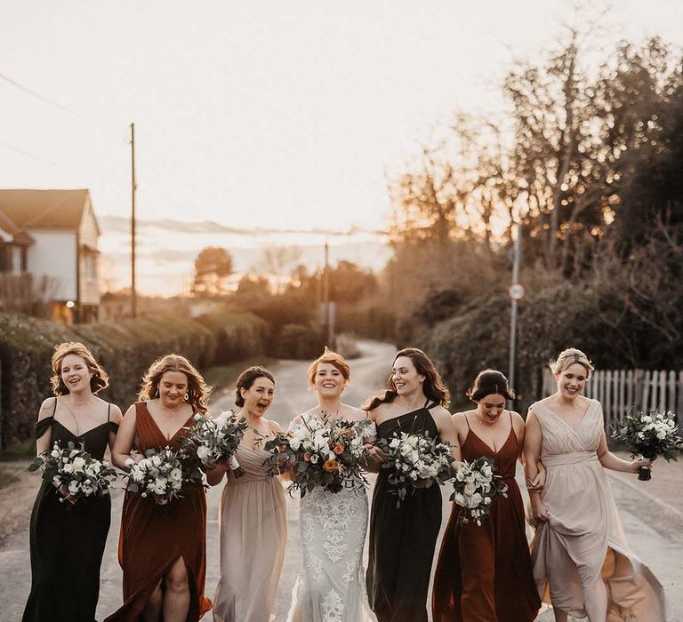 Bridesmaids in cream, rust and brown dresses earth toned, with bride in lace Maggie Sottero wedding dress 