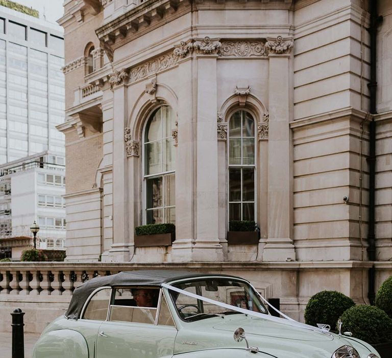 Mint green classic wedding car with white ribbon