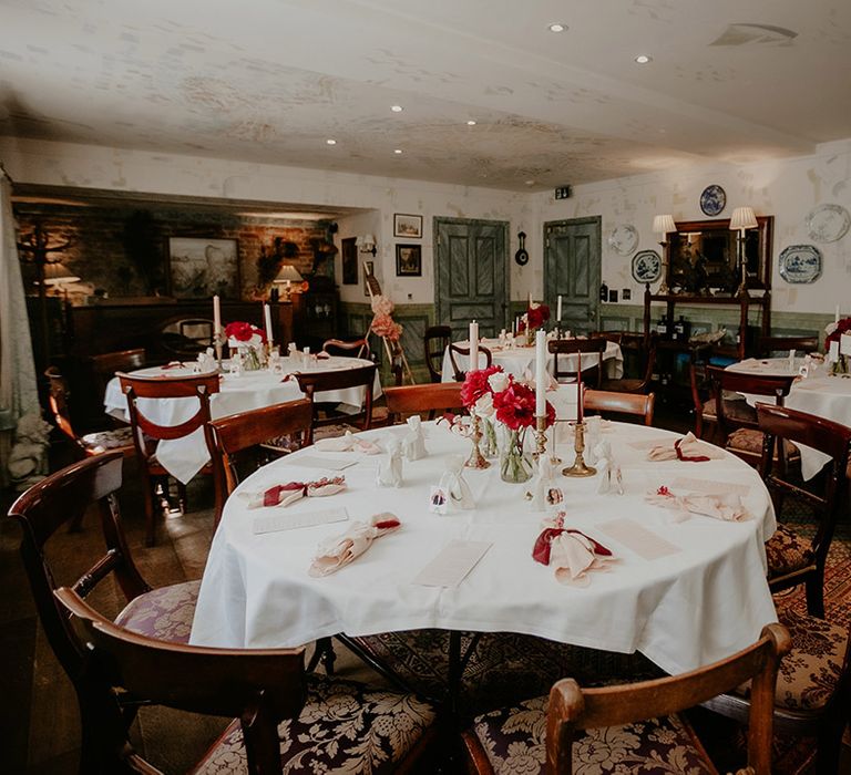 Red and white flower centrepieces with pink and white candles in gold candle holders reception room at The Zeffer Townhouse venue 