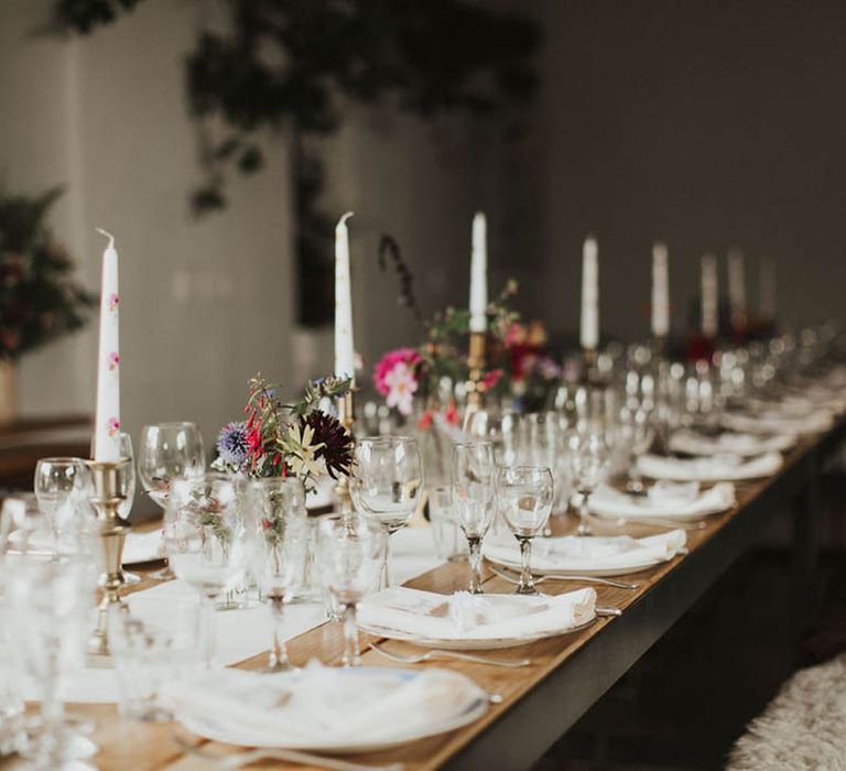 Floral hand painted white taper candles with a simple table setting 