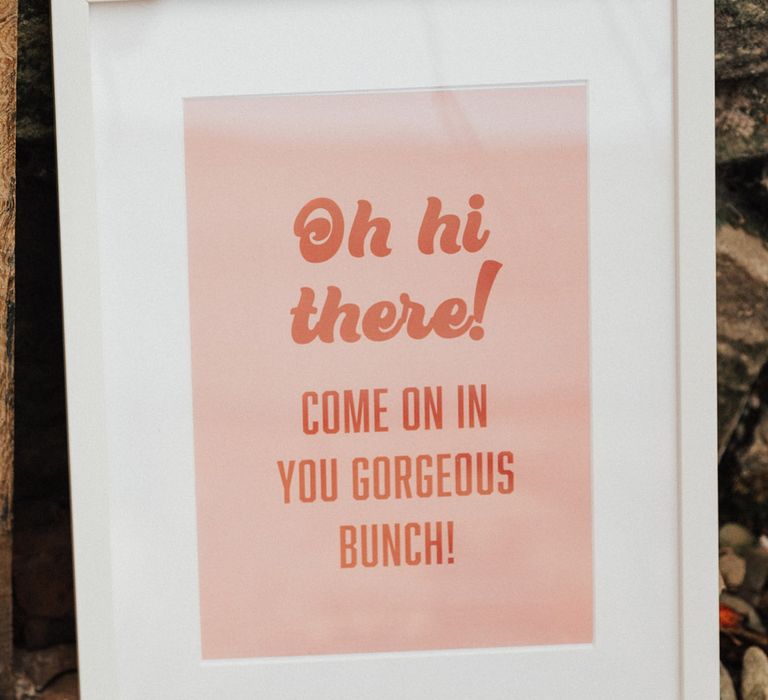 Pink and orange wedding welcome sign in a white frame 