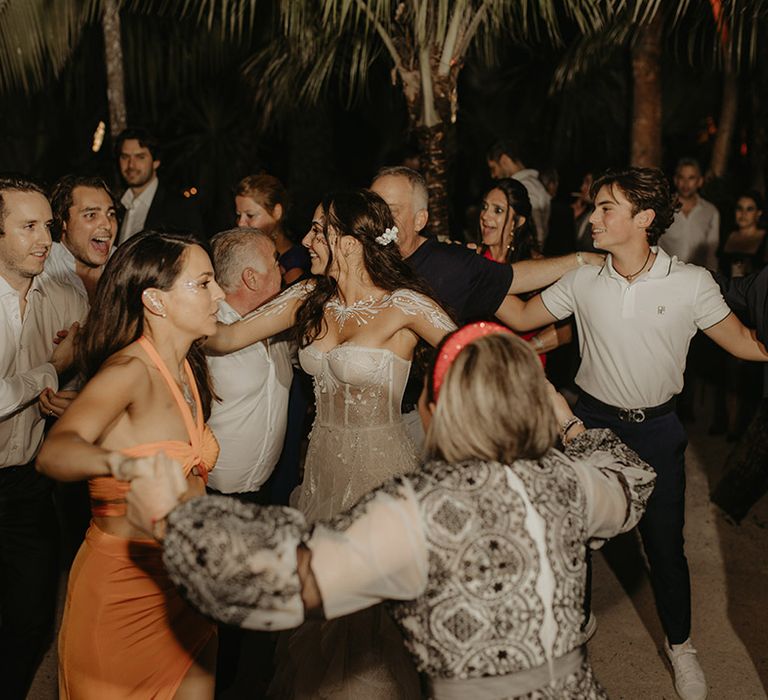 Bride & groom dance outdoors during rave wedding reception in the jungle 