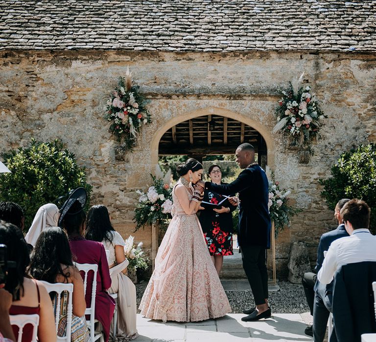 Panjabi Bride kisses Jamaican Grooms hand during multicultural wedding ceremony