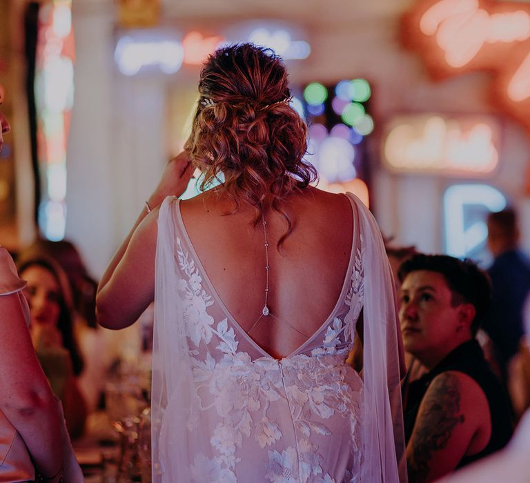 Bride wearing open back lace wedding dress with diamond and silver body chain 