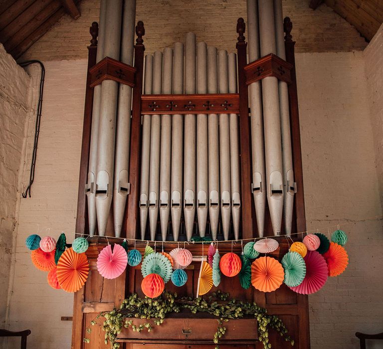 Colourful wedding fan decor across organ during civil ceremony 