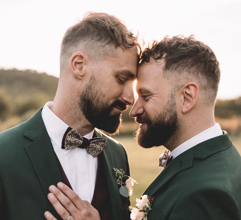 Two grooms wearing green groom suits with floral patterned bow ties for their secular ceremony in France 