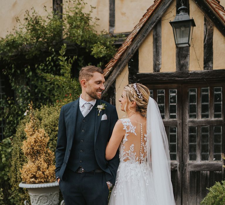 Bride in button back illusion Dando London wedding dress with the groom in dark blue suit at Dove Barn Weddings 