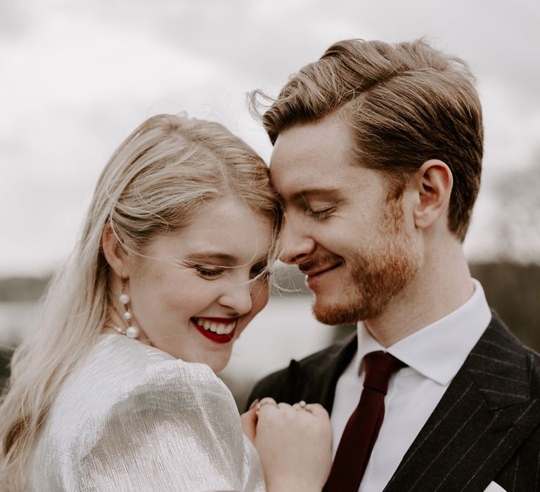 Groom in pinstriped suit with red tip for gothic Halloween wedding with the bride in a metallic wedding dress 