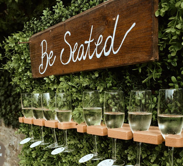 Wedding prosecco wall with greenery at destination wedding in Tuscany